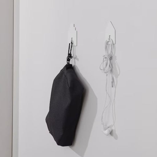 The Hook adding a decorative touch to a bedroom wall, with a bag hanging from it