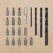 A set of various drill bits and screwdriver bits arranged neatly on a wooden surface. There are 16 screwdriver bits of different types and sizes, one bit holder, and five drill bits of varying diameters. The screwdriver bits include flathead, Phillips, and Torx types, while the drill bits are of different lengths and thicknesses-50568085