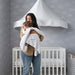 Baby wrapped in a soft white IKEA LEN blanket, held by a caregiver near a crib with a canopy, set in a cozy room with grey cloud-patterned wallpaper-40496433