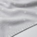 Close-up of a soft, white IKEA LEN blanket with a textured surface and raised dot pattern. Features neatly stitched edges for a durable and cozy feel.-40496433