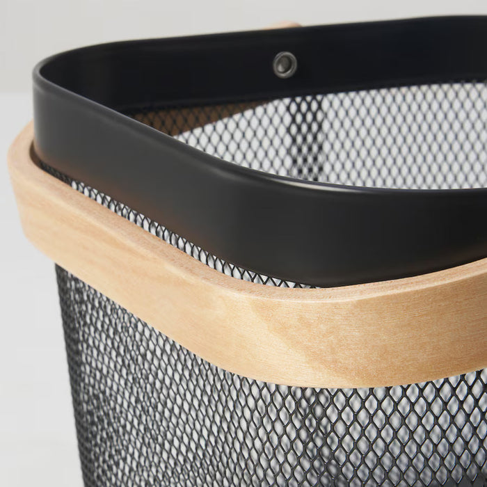 Dark grey IKEA RISATORP basket, 25x26x18 cm (9 ¾x10 ¼x7 "), featuring a sturdy black metal mesh body with a natural wooden rim. Modern and functional, ideal for stylish home storage. The close-up highlights the reinforced black metal band with a rivet, showcasing quality craftsmanship. Perfect for kitchen, office, or living room organization.-00588712
