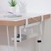 The IKEA FÖRSÄSONG Cable Management Tray, measuring 38 cm in white, is shown attached to the underside of a desk using two brackets. The tray is constructed from mesh material and is used to organize cables and small items. On the desk, there's a smartphone, a pen, and a small potted plant. Inside the tray, you can see a stapler and other office supplies. This setup illustrates an effective solution for maintaining a tidy and organized workspace by efficiently managing cables and small items.80573189