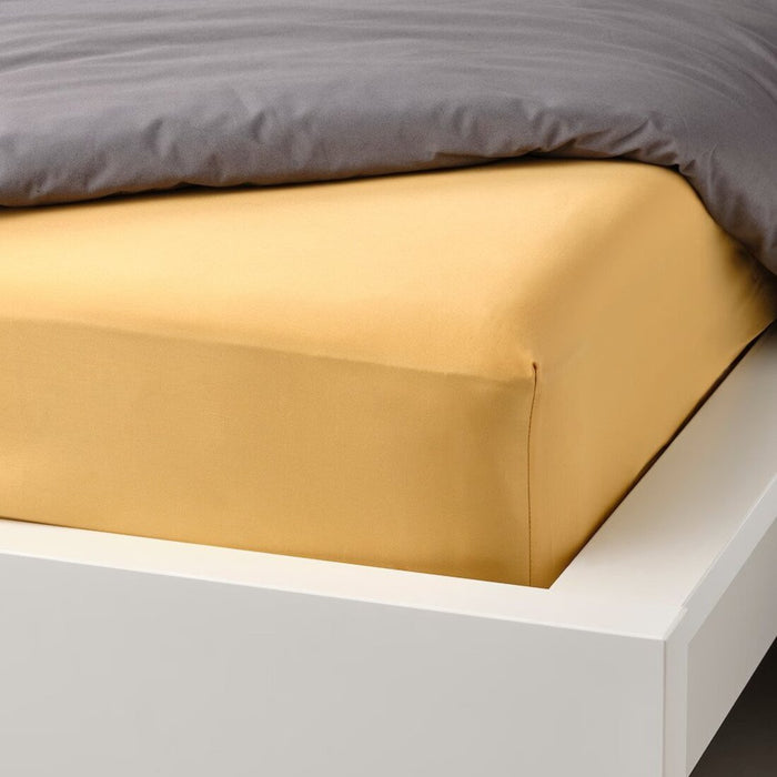 A closeup image of IKEA fitted sheet on a bed with neatly tucked corners and a smooth surface 