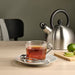 Digital Shoppy Tea infuser placed on a saucer next to a teapot and loose leaf teas 20545024