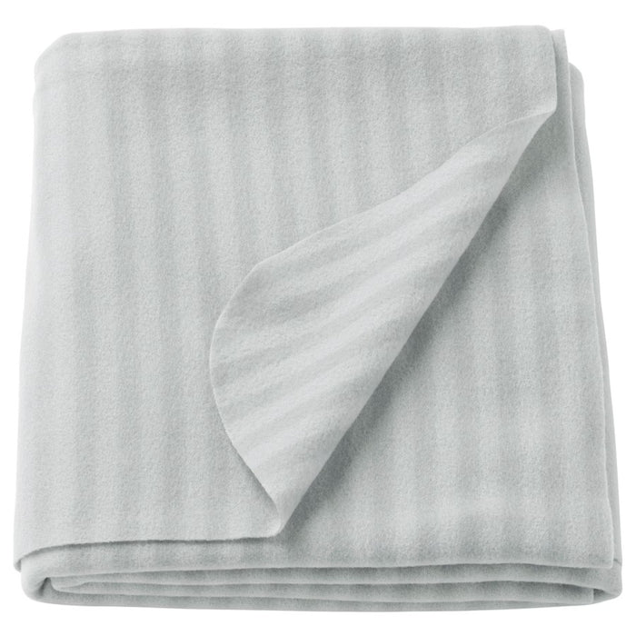 Folded light gray fleece blanket with a subtle striped pattern, soft and cozy texture, ideal for home or travel use.-70304890