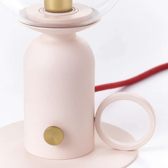 Compact IKEA ÅSKMULLER dimmable table lamp in light pink and red, ideal for mood lighting. The 24 cm (9-inch) lamp has an on/off switch and adjustable brightness.30576232