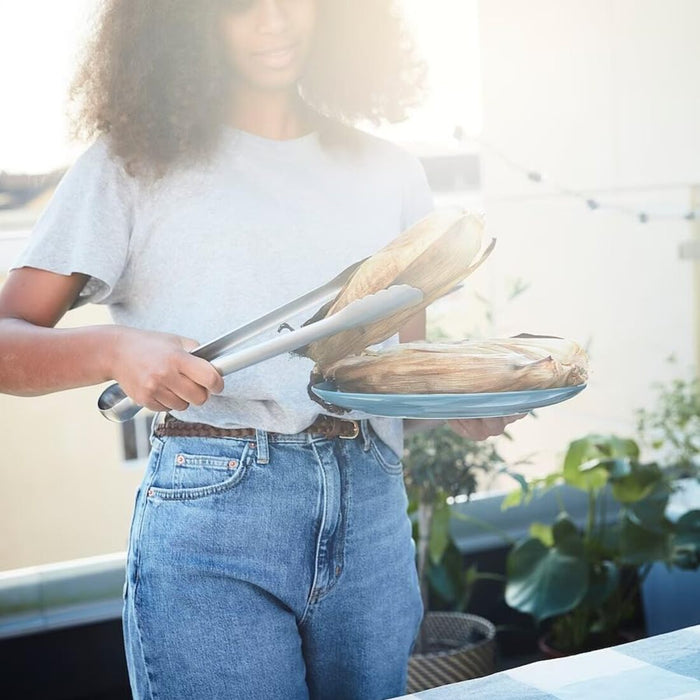 Stylish and functional IKEA GRILLTIDER 3-piece BBQ tools set on a dining table outdoors. 70541924