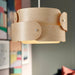 Wooden pendant light fixture with a colorful abstract painting in the background