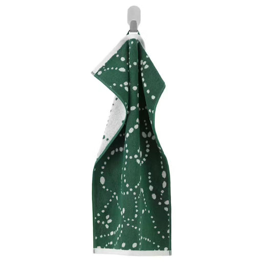 Green towel with white pattern on a mannequin against a white background