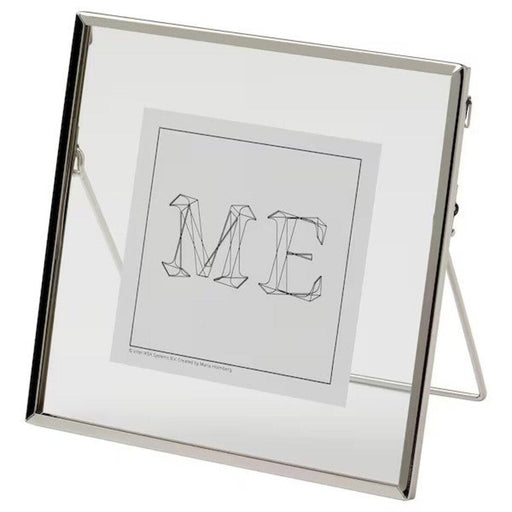 IKEA LERBODA metal frame in silver, 16x16 cm, with a clear glass front and a geometric typography print inside. Minimalist home decor photo frame with a fold-out stand.40516308