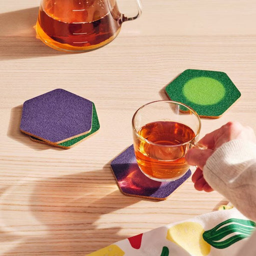 IKEA TABBERAS coasters neatly arranged on a coffee table, protecting the surface from drink spills