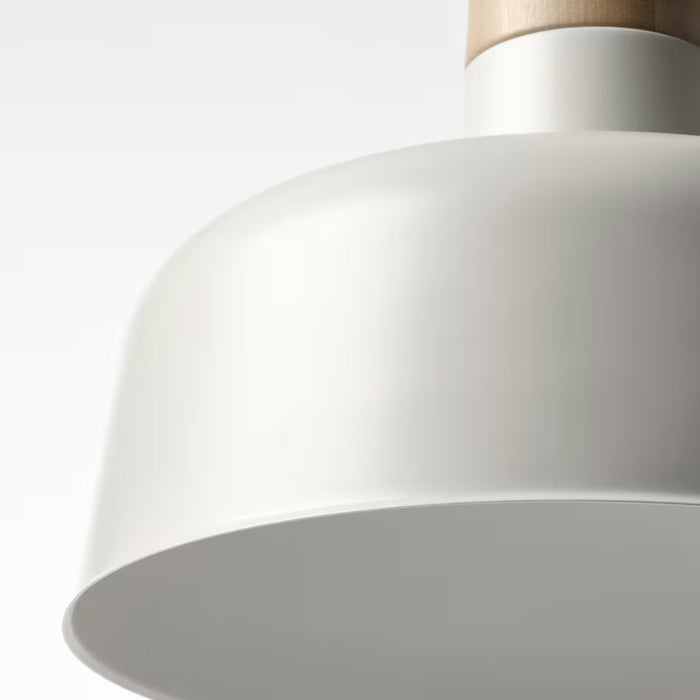 Close-up of a sleek, minimalist pendant lamp with a white, dome-shaped shade and a natural wood accent at the top. The lamp is suspended by a white cord, showcasing a clean and modern design ideal for contemporary interiors.