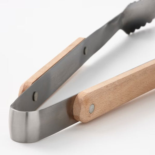 Close-up of tongs: "Durable stainless steel and beech wood barbecue tongs for precise and stylish grilling