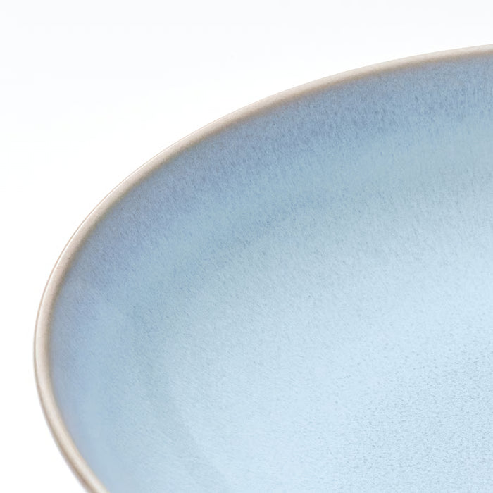 Close-up of light blue FÄRGKLAR stoneware plate showing handcrafted reactive glaze texture