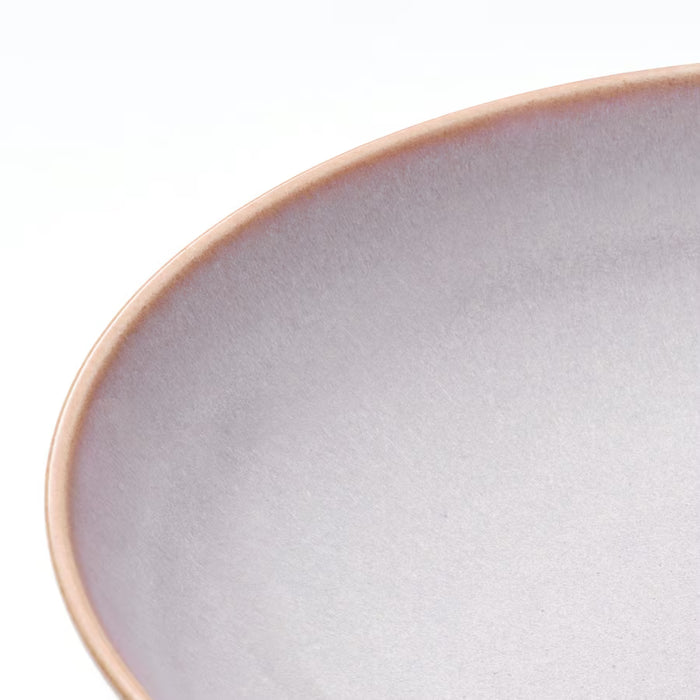 Close-up of IKEA FÄRGKLAR light pink stoneware plate showing unique reactive glaze texture and smooth rim