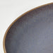Close-up of IKEA FÄRGKLAR lilac deep plate showing textured reactive glaze rim