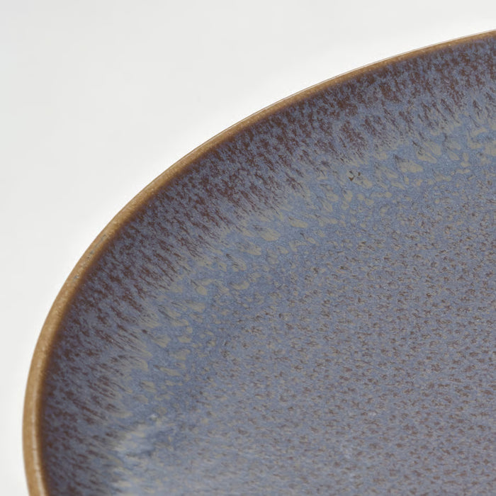 Close-up of IKEA FÄRGKLAR lilac plate edge showing glossy speckled glaze detail
