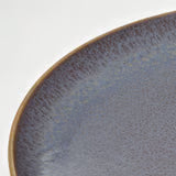 Close-up of IKEA FÄRGKLAR lilac plate showing textured glazed surface and smooth edge