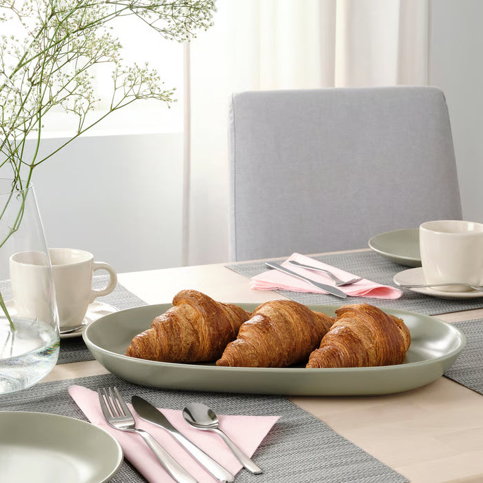 IKEA FÄRGKLAR matt green serving plate styled on a wooden table with croissants, mugs and napkins