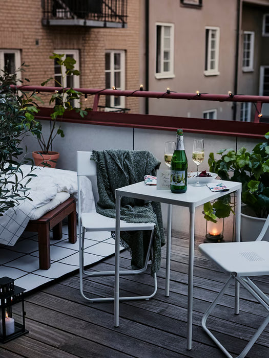IKEA FEJAN white outdoor table styled on modern balcony with plants and lantern