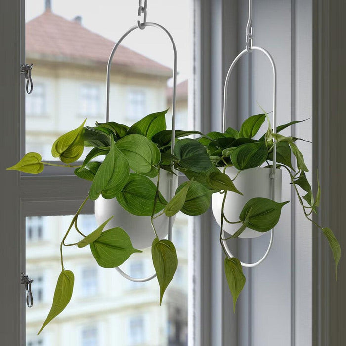 "Artificial Golden Pothos plant by IKEA, designed for both indoor and outdoor settings. Features trailing vines with heart-shaped green leaves in a 12 cm (4 ¾ inch) diameter black pot-50578070    