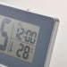 IKEA FILMIS grey LED alarm clock with backlight on, clear digital display showing time and temperature, close-up