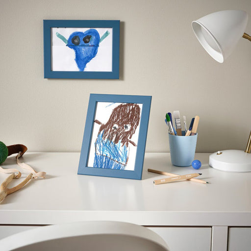 FISKBO frame in dark grey-blue, holding an art print on a living room shelf
80584927