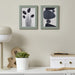 Two abstract art pieces in green frames on a wall above a white shelf with decor items.