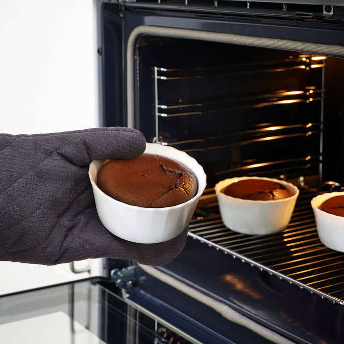 Hand in oven mitt removing hot chocolate lava cake from IKEA FISKTÄRNA white dish