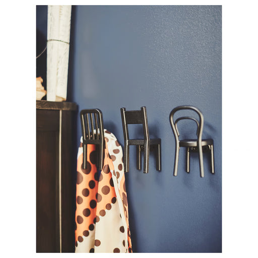 IKEA FJÄNTIG black chair hooks on wall holding polka dot fabric in home setting