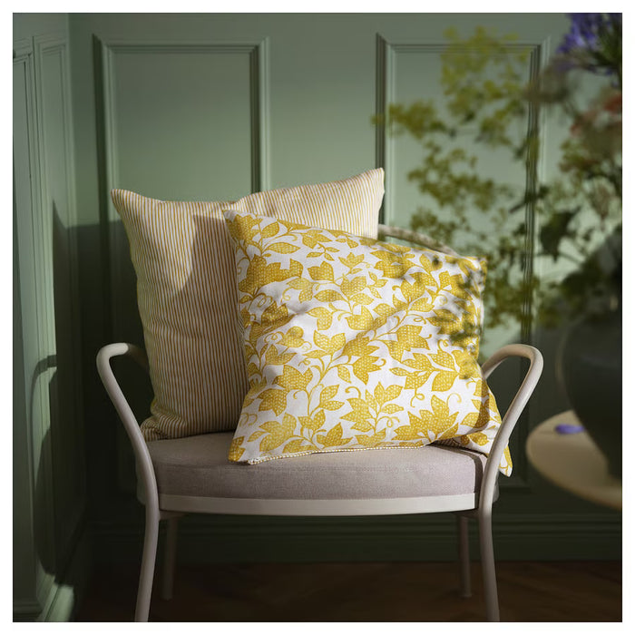 IKEA FJUNKLOCKA yellow white cushion covers styled on white chair against green wall living room setting