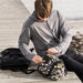 Person packing a plastic bottle into IKEA FLADDRIG grey patterned lunch bag with utensil print