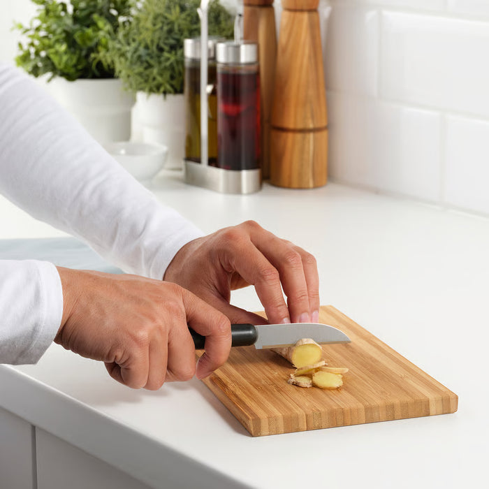  Person chopping ginger on wooden cutting board with IKEA FÖRDUBBLA cook's knife in a clean kitchen