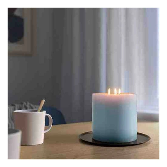 An unscented block candle from IKEA, emitting a warm and inviting glow that creates a cozy atmosphere in any room.