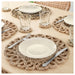 Six IKEA GALLSOPP woven place mats with white plates and glasses arranged on a wooden dining table