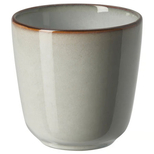 A single, stoneware IKEA GLADELIG espresso cup in a light grey color with a slightly darker, rustic brown rim, shown on a white background
