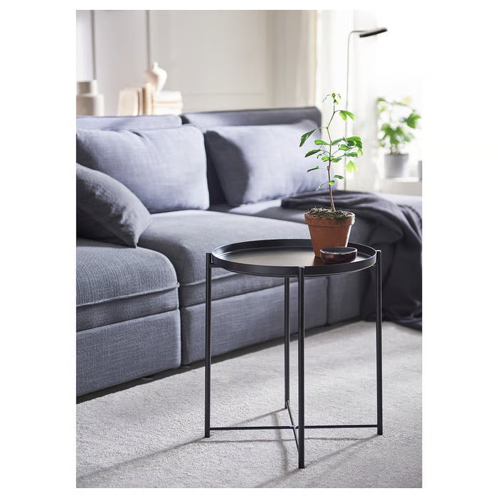 IKEA GLADOM black side table in modern living room beside grey sofa holding potted plant and small tray
