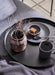  IKEA GLADOM black removable tray with handle carrying coffee cup bowl spoon and vase with branches