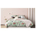IKEA GLADOM white tray table in a compact bedroom used as a bedside table with phone and glass