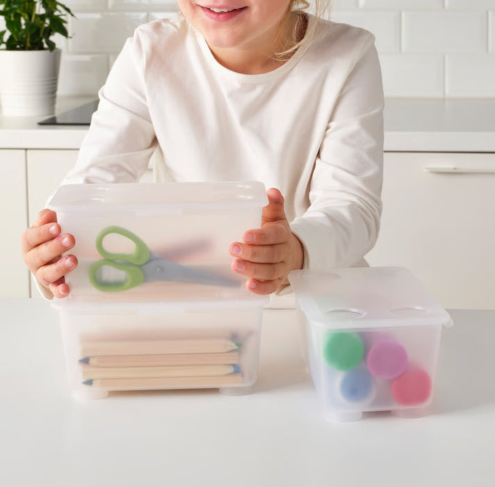 Hand holding open IKEA GLIS pink turquoise plastic box with lid containing scissors and pencils
