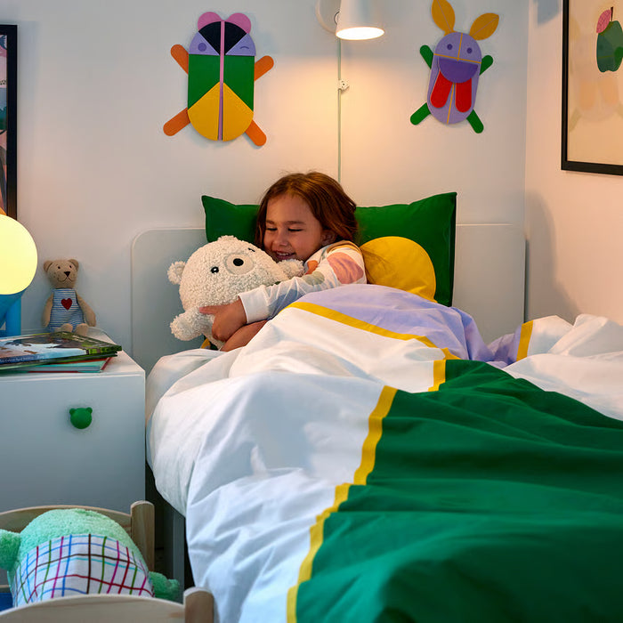 Child sleeping on IKEA GREJSIMOJS bedding with teddy bear and colourful pillows in bedroom
