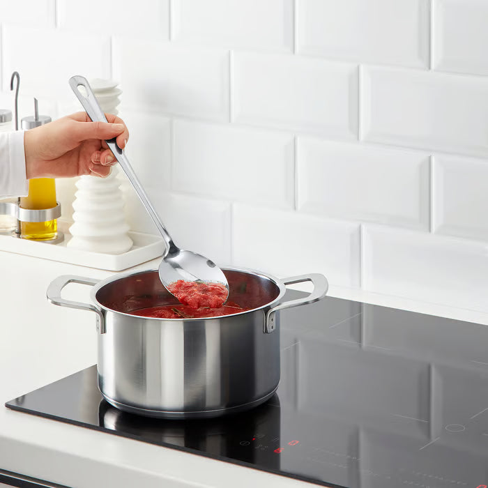 IKEA GRUNKA stainless steel spoon stirring red sauce in a pan on a modern hob