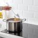 IKEA GRUNKA spaghetti server being used to plate pasta on a stovetop