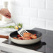 IKEA GRUNKA ladle scooping soup from a pot on an induction stove in a modern kitchen