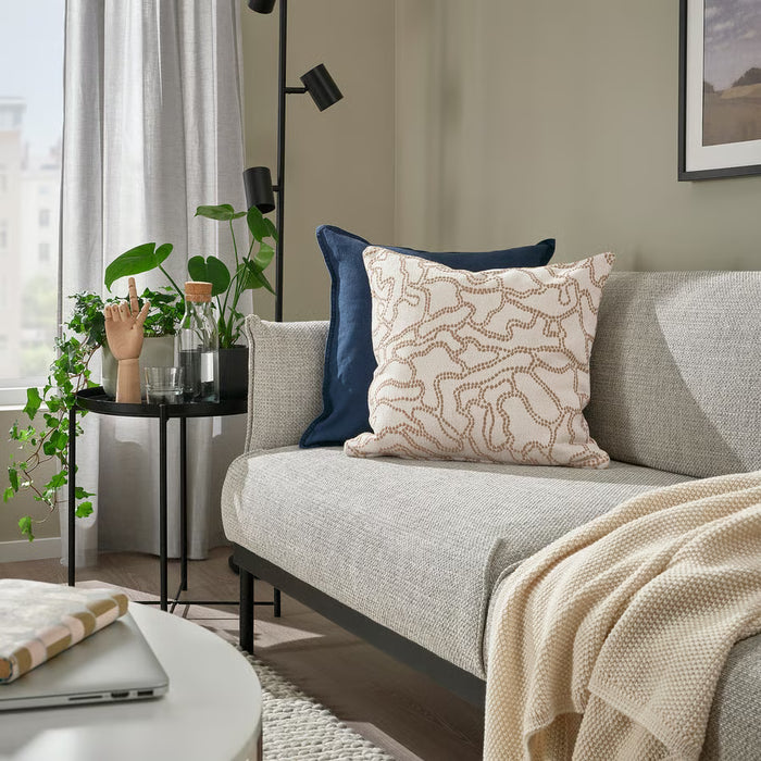 Living room with a gray sofa, decorative pillows, and a small table with plants.