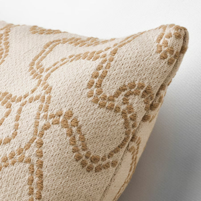 Close-up of a beige pillow with brown floral pattern on a neutral background