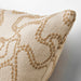 Close-up of a beige pillow with brown floral pattern on a neutral background