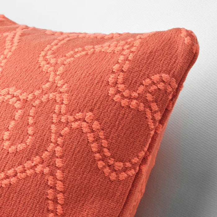 Close-up of a textured coral cushion on a light gray background