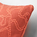 Close-up of a textured coral cushion on a light gray background