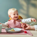 IKEA GULDVÄVARE infant bib in delicate pale pink featuring a deep food-catching pocket and comfortable neck sizing, machine-washable for convenient reuse.

